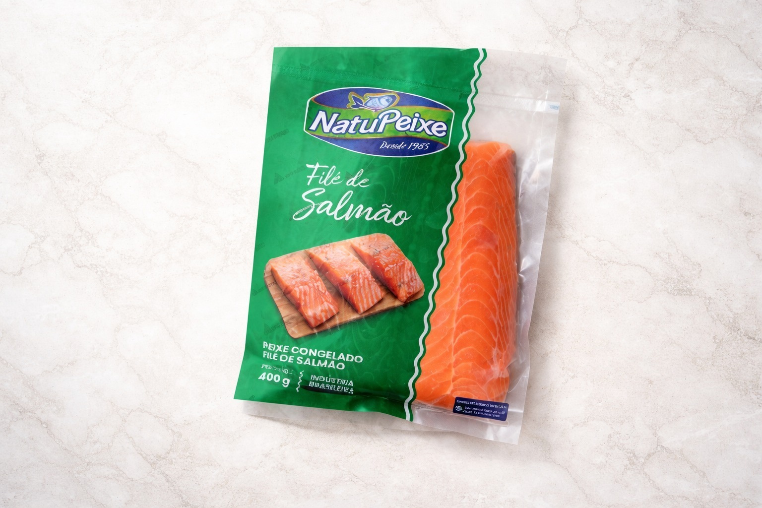 Embalagem a vácuo de filé de salmão congelado NatuPeixe 400g sobre superfície de mármore